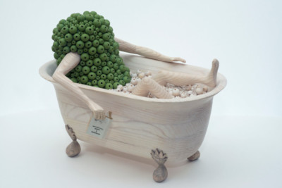 Apprendre à nager - François LACOSTE Sculpture en bois : bras et jambes émergeant d'un nuage de perles vertes se prélassant dans une baignoire