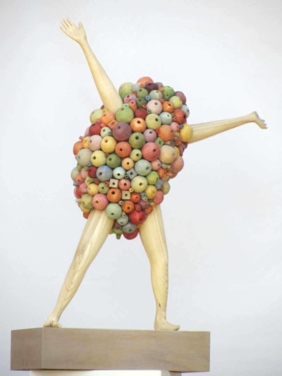 2 secondes avant l'invention de la roue - François LACOSTE Sculpture en bois : bras et jambes émergeant d'un nuage de perles multicolores dans une attitude victorieuse