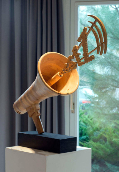 Assez - François LACOSTE Sculpture en bois d'un mégaphone dont jailli le mot ASSEZ.
