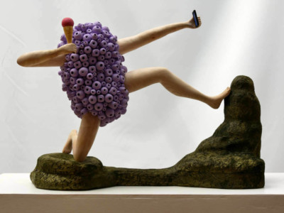 La mythologie n'est plus ce qu'elle était - François LACOSTE Sculpture en bois : bras et jambes émergeant d'un nuage de perles violettes se prenant en selfie avec une glace à la main