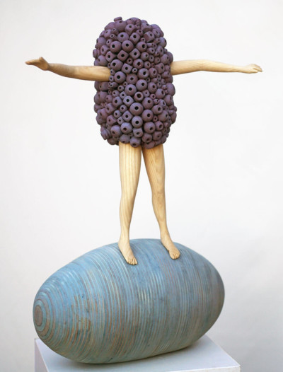 Sur la vague - François LACOSTE Sculpture en bois : bras et jambes émergeant d'un nuage de perles violettes tenant l'équilibre sur une vague